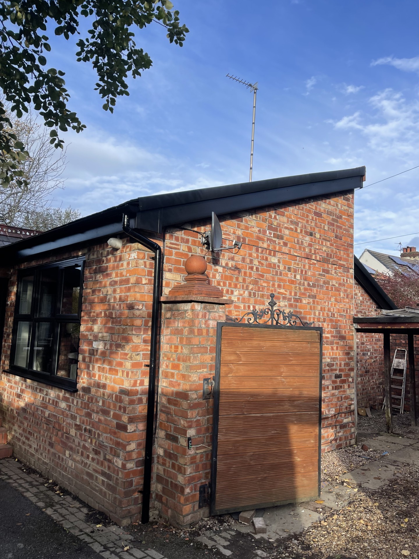 Black fascia and guttering on brick building